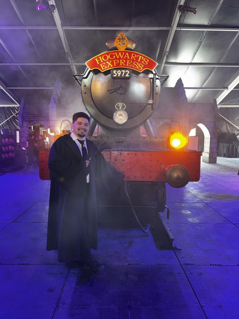 A guest in Hogwarts robes at the Hogwarts Express 5972 locomotive photo op