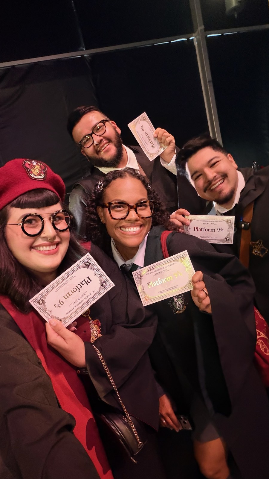 Guests in Hogwarts robes holding replica Platform 9 3/4 round trip tickets